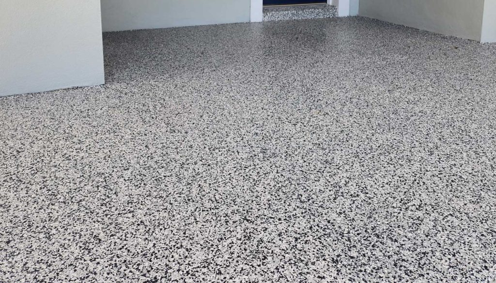 Black and white vinyl flaked epoxy garage floor.