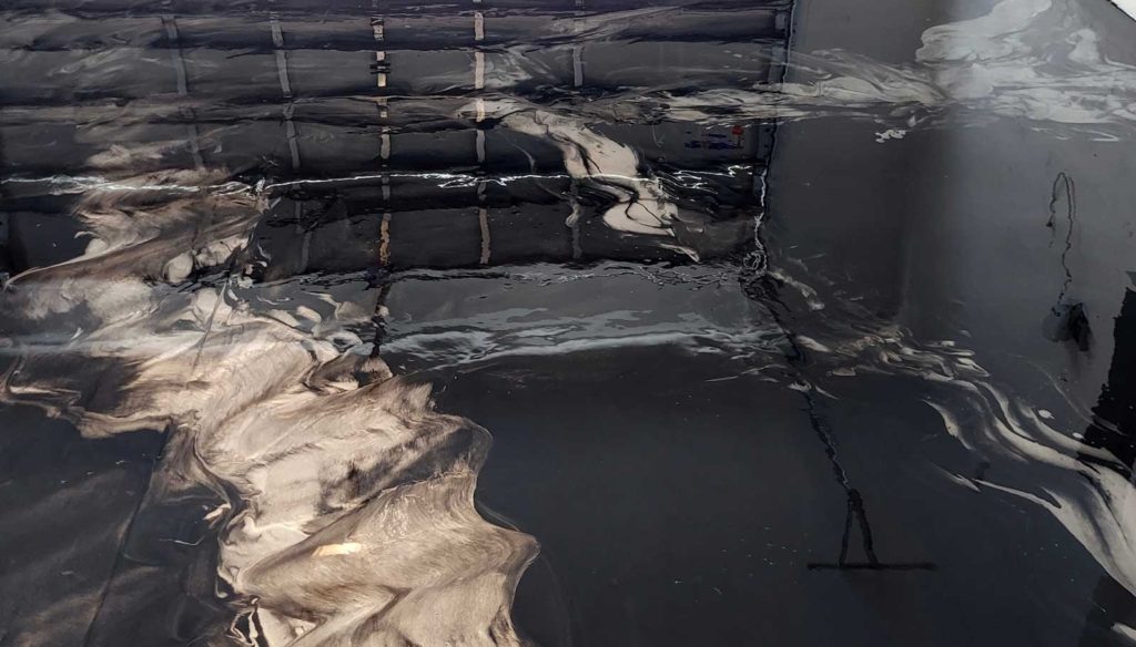 Black and silver epoxy paint swirled on a floor.