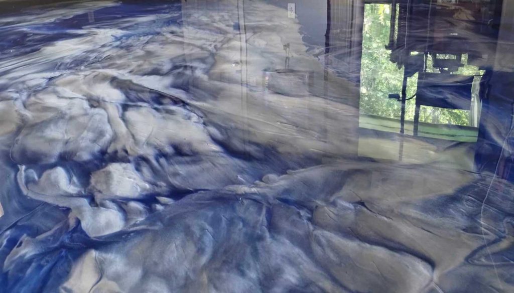 Blue and white epoxy paint swirled on a floor to look like clouds.