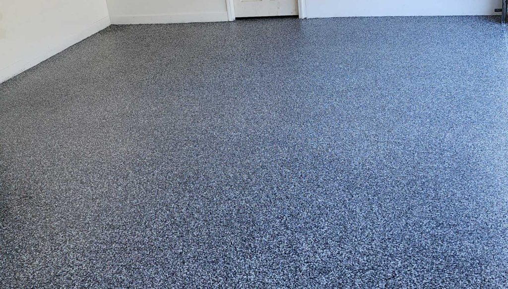 Blue and white vinyl flaked epoxy floor in a garage.