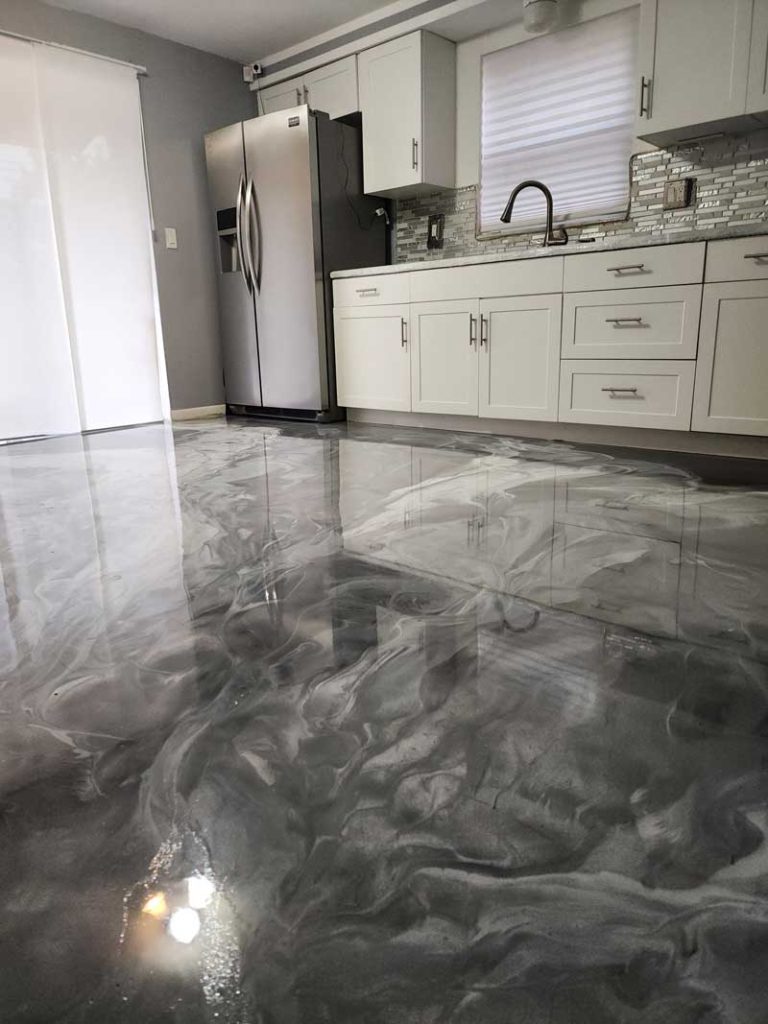 Dark gray and white epoxy paint swirled on a kitchen floor