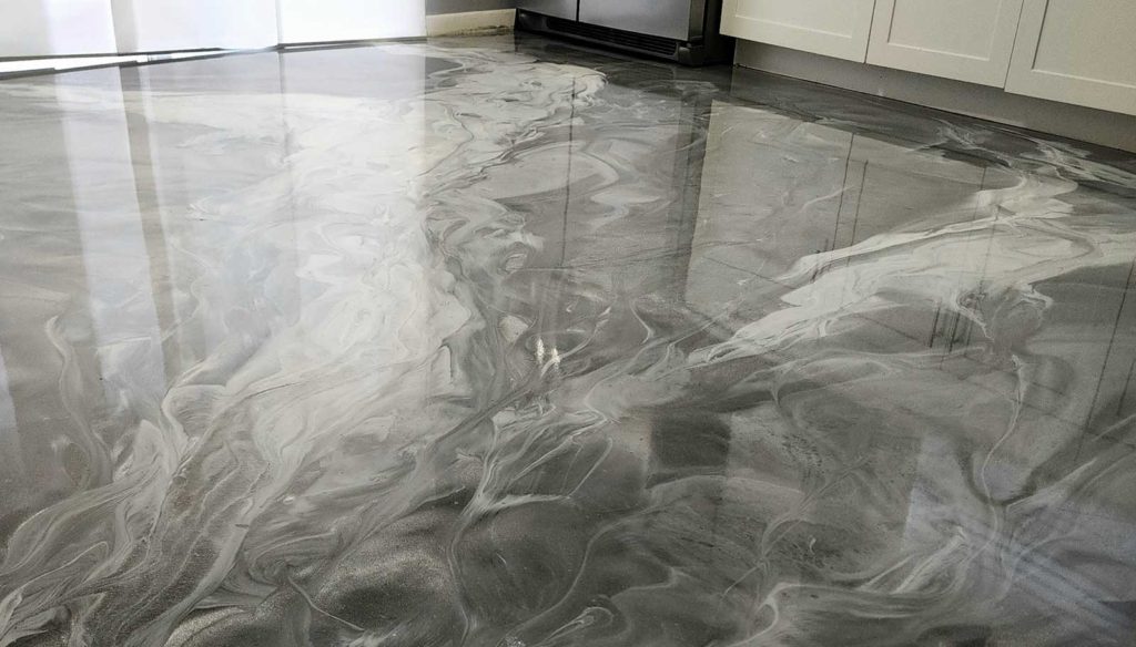 Dark gray and white epoxy paint swirled on a kitchen floor.