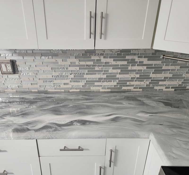 Gray and white epoxy paint swirled on a kitchen countertop.