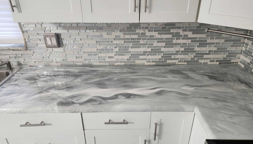 Gray and white epoxy paint swirled on a kitchen countertop.